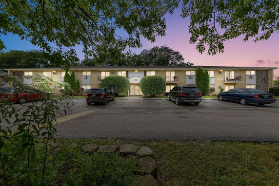 Front view of a two-story apartment building with parking area.