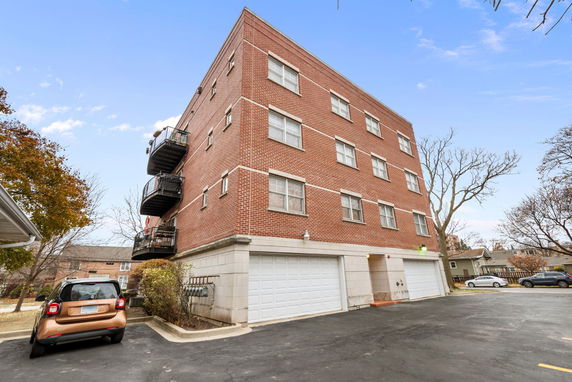 Front view of a multi-story brick apartment building with balconies.
