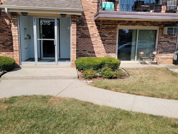 Front view of a brick apartment building with a glass entrance door.