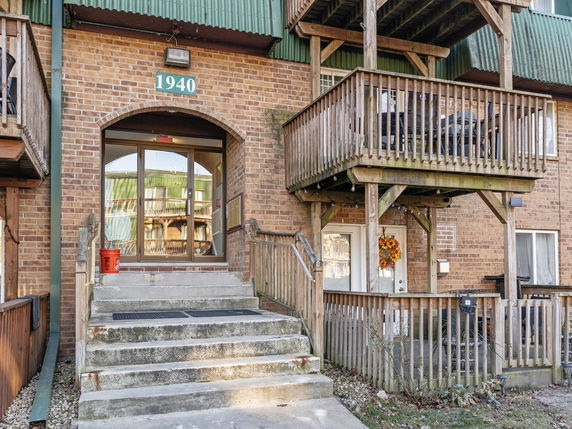 Front view of a multi-story brick apartment building with wooden balconies.