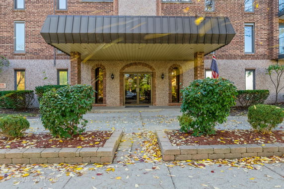 Front view of a building entrance with glass doors and brick walls.