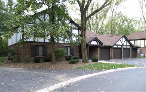 Front view of a two-story house with multiple garages and gabled roofs.