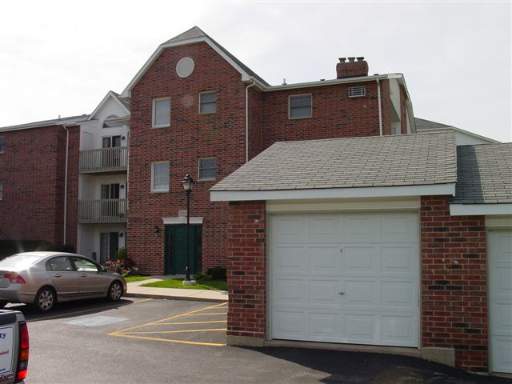 Front view of a multi-story brick apartment building with a garage.