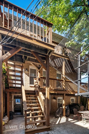 Rear view of a multi-story brick building with wooden staircases and balconies.