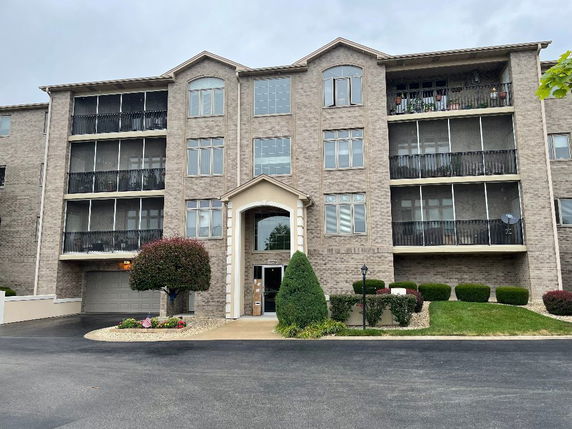 Front view of a multi-story apartment building with balconies.