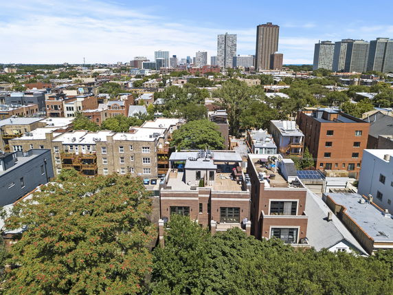 Aerial view of an urban area with various residential buildings and trees.