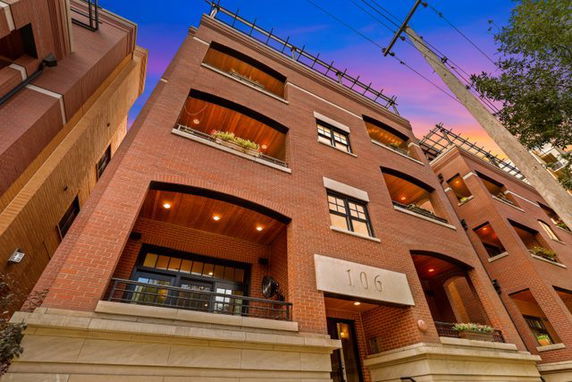 Front view of a multi-story building with brick exterior and balconies.