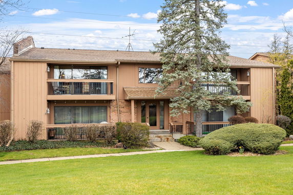 Front view of a two-story house with balconies and a central entrance.