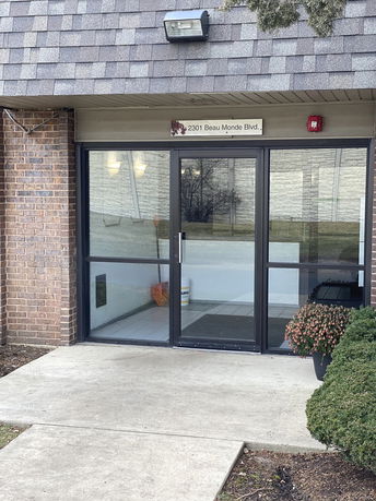 Front view of a building with a glass entrance and brick exterior.