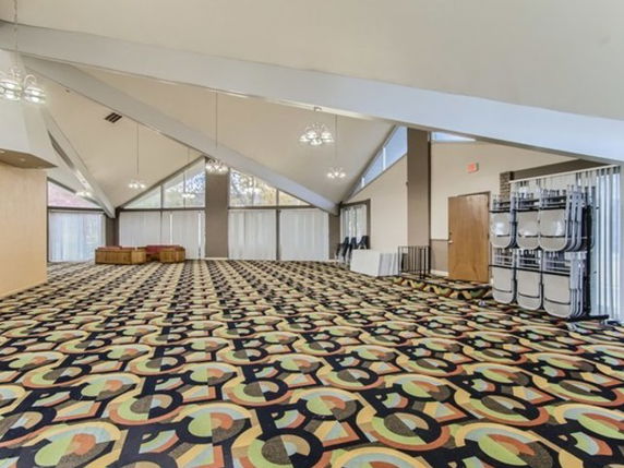 Large indoor space with geometric patterned carpet and high ceiling, used for recreational activities.