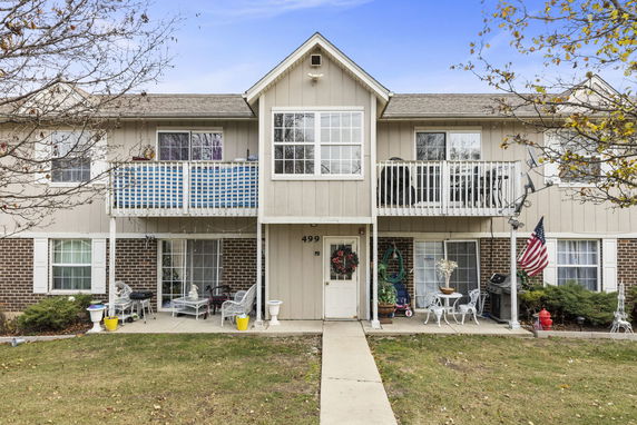 Front view of a two-story residential building with a walkway leading to the door.