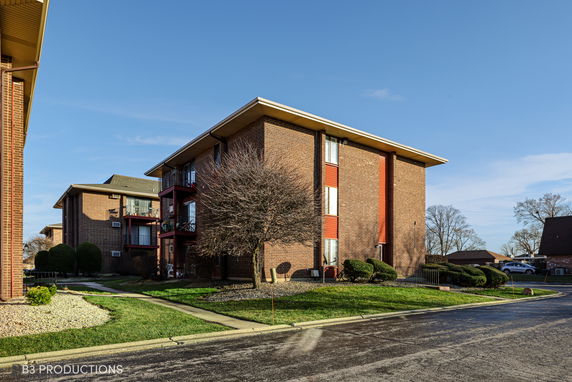 Front view of a multi-story brick apartment building.