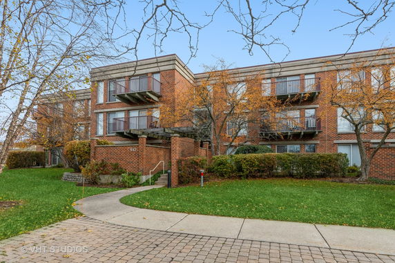 Front view of a brick multi-story building with balconies.