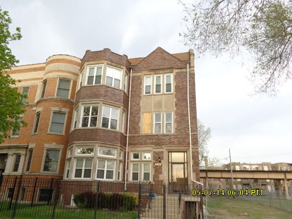 Front view of a multi-story brick building with large windows.
