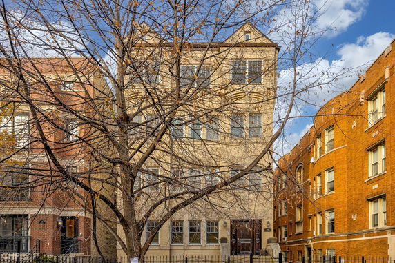 Front view of a multi-story residential building with brick facade.