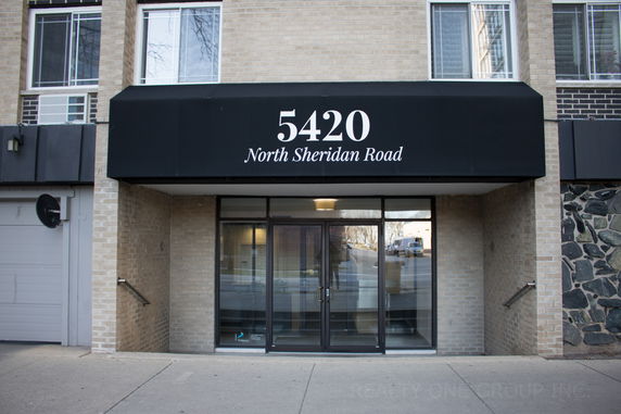 Front view of a building entrance with a black awning displaying the address 5420 North Sheridan Road.
