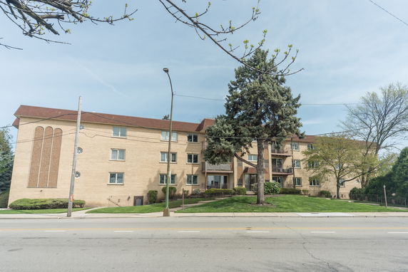 Front view of a multi-story brick apartment building.