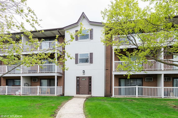 Front view of a three-story apartment building with balconies.