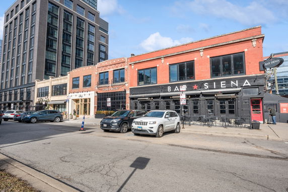 Front view of a commercial building with multiple businesses, including a bar and restaurant.