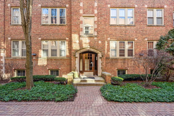 Front view of a multi-story brick building with decorative entrance.