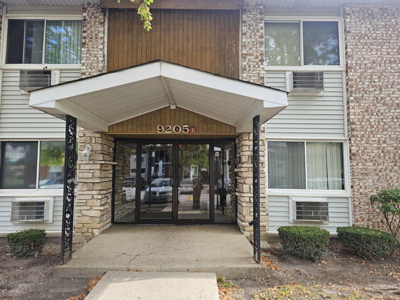 Front view of a multi-story building with a covered entrance.