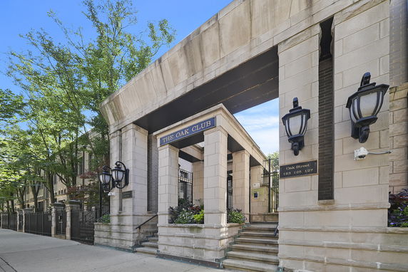 Front view of a building entrance with stone pillars and name plaque reading 'The Oak Club'.