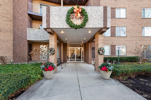 Front view of a building entrance with holiday decorations.
