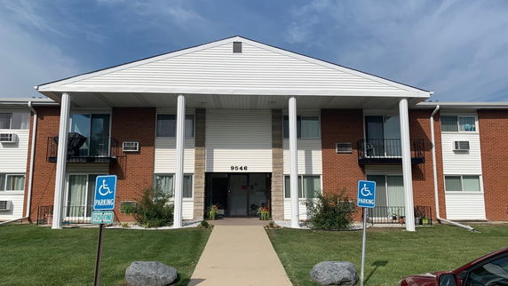 Front view of a two-story residential building with columns and balconies.