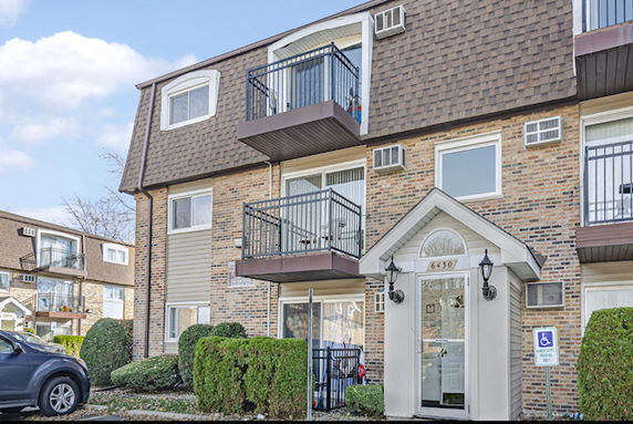 Front view of a multi-story residential building with balconies.