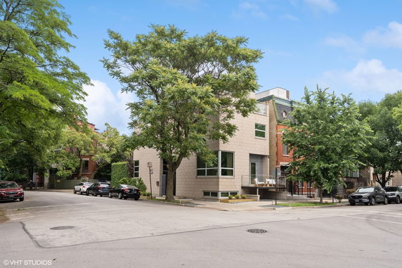 Front view of a modern multi-story house on a corner lot.