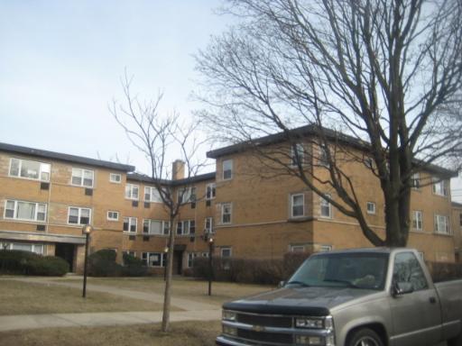 Front view of a multi-story brick building with large windows.