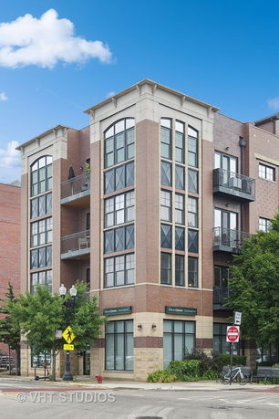 Front view of a multi-story building with large windows and balconies.