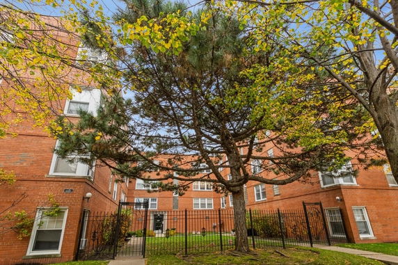 Front view of a brick apartment building with multiple stories.