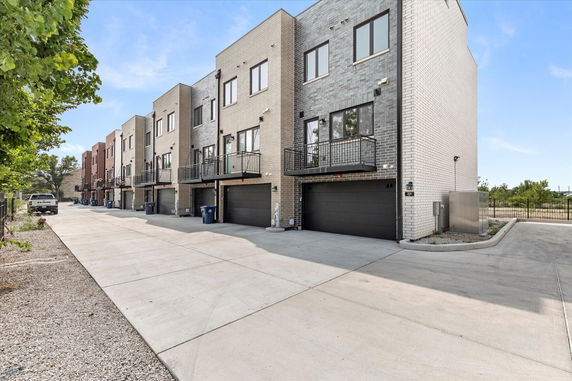 Front view of a row of modern multi-story houses with garages.