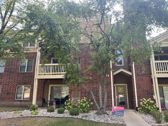 Front view of a multi-story building with brick exterior and balconies.