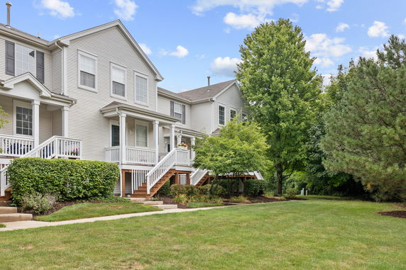 Front view of a two-story house with white siding and a porch.