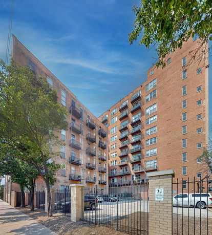 Front view of a multi-story apartment building with balconies.