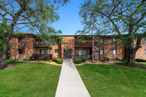 Front view of a brick apartment building with balconies.