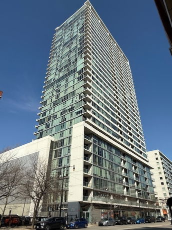 Front view of a tall modern high-rise building with glass windows.