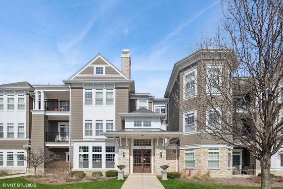 Front view of a multi-story building with a gabled roof and stone accents.