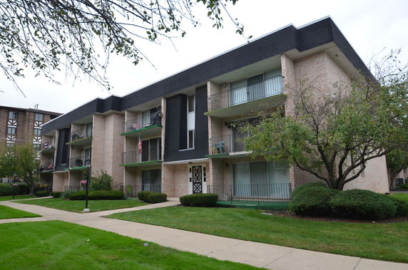 Front view of a multi-story apartment building with balconies.