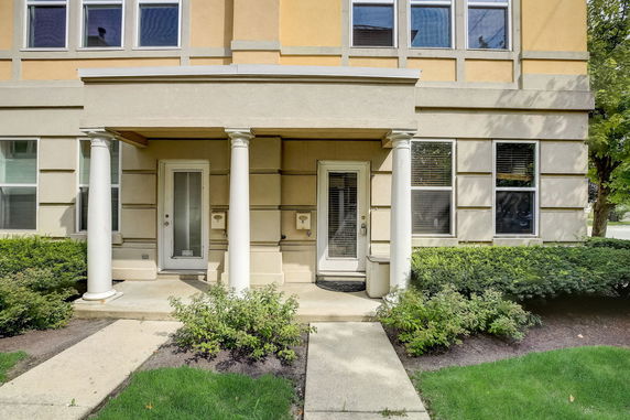 Front view of a house with two entry doors and columns.