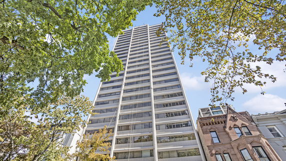 Front view of a tall residential building with multiple floors.