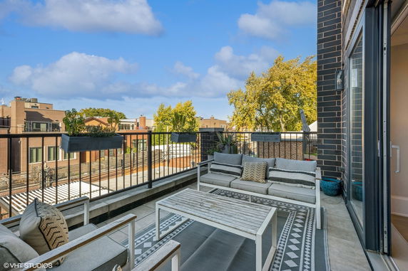 Rooftop seating area with outdoor furniture and a view of surrounding buildings.