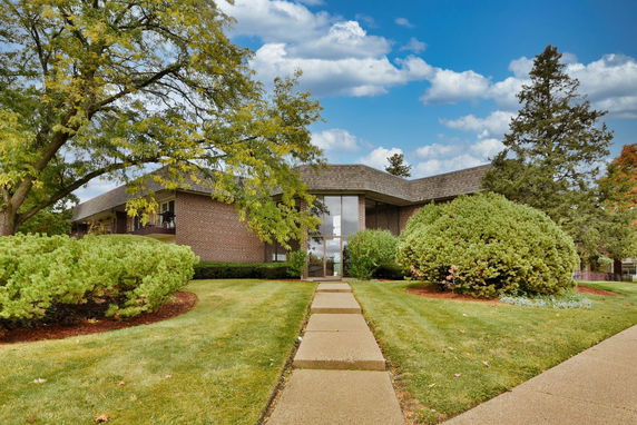 Front view of a single-story brick building with a pathway leading to the entrance.