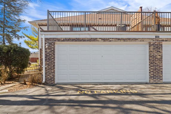 Front view of a house with a two-car garage and rooftop railing.