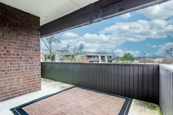 View from a balcony overlooking a residential area with cloudy sky.