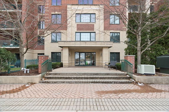 Front view of a multi-story brick building with entrance steps.