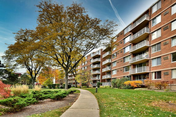Front view of a multi-story brick apartment building with balconies.