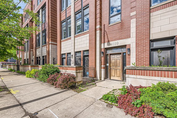 Front view of a multi-story building with brick facade and large windows.